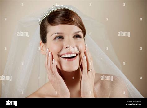 A young bride smiling, hands resting on her face Stock Photo - Alamy