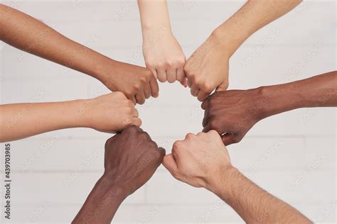 Multiethnic people holding hands in a circle together, multiethnic business team promising help ...