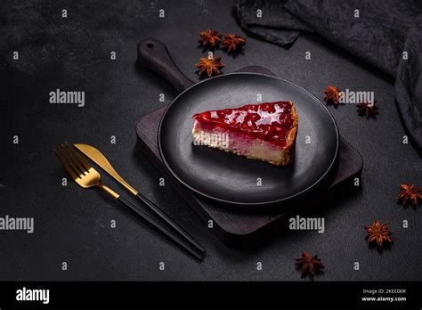 Homemade tasty cheesecake with jelly and raspberry berries on a black