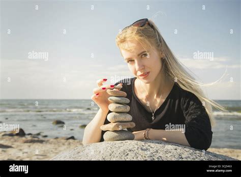 Beautiful woman stacking stones hi-res stock photography and images - Alamy