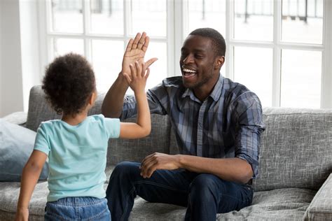 Happy black dad and son giving high-five playing at home | The PLAY Project