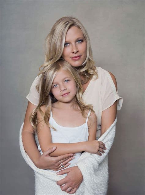 Mother Of A Daughter - a mother and daughter hugging each other in front of a gray background ...