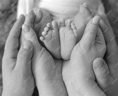 Premium Photo | Newborn baby feet in parents hands