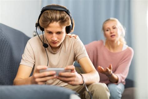 Teenager Absorbed in Game on Phone, Ignoring Mother Talking To Him ...