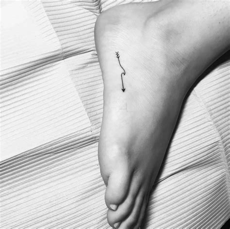 Wave arrow tattoo on the right foot.