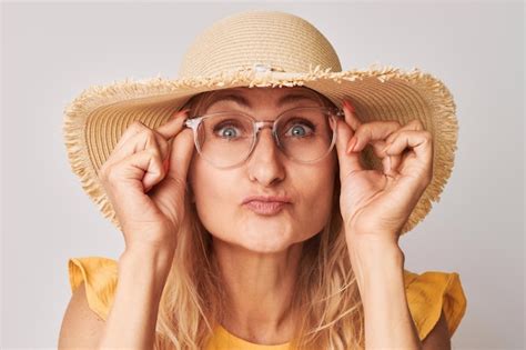 Портрет 50-летней женщины, щурящейся в очках, изолированных на белом ...