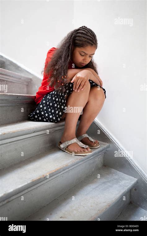 Sad little girl sitting on the stairs Stock Photo - Alamy