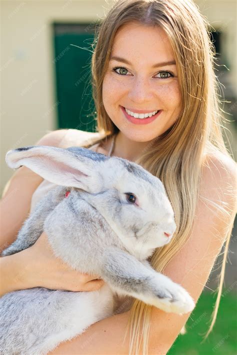 Premium Photo | Beautiful young woman with bunny rabbit on farm