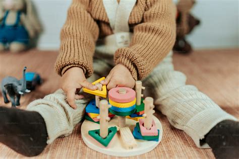 A young child playing with toys on the floor photo – Wooden toys Image