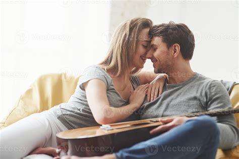 In love with each other. Guitar on the legs. Happy couple relaxing on
