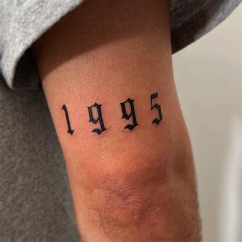 "1995" lettering tattoo located on the tricep.