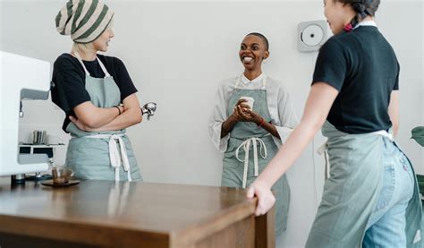 Happy multiethnic female baristas discussing ideas during breakFree