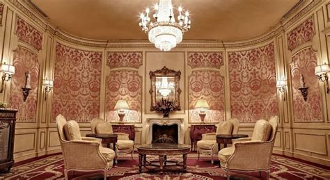 an ornate living room with chandelier and chairs