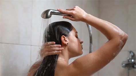 Frau in der Dusche spült Gesicht und Haare in Zeitlupe 10939661 Stock