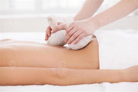 Massage for tired muscles. Side view of woman lying on front while