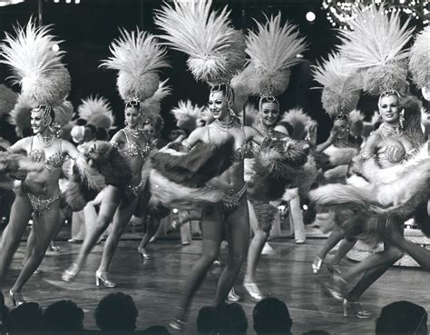 Showgirls with feather boas and headpieces performing onstage for the