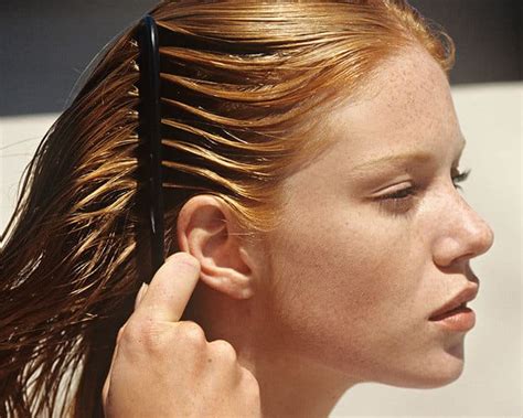 Young woman combing her hair, outdoors