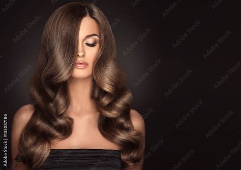 Brunette girl with long and shiny wavy hair . Beautiful model with ...