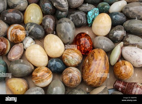 Background of colorful onyx stone eggs of different colors on a wooden ...