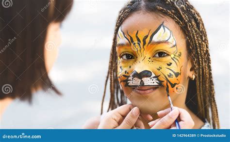 Little Girl Getting Her Face Painted by Face Painting Artist. Stock ...