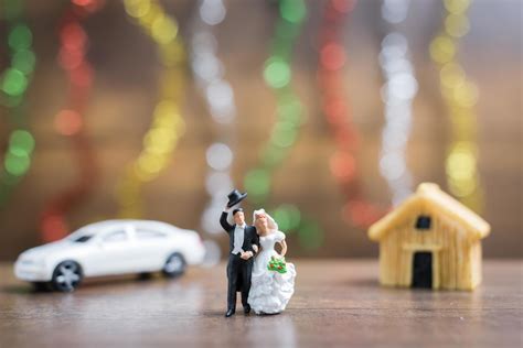 Miniature bride and groom on a wooden floor with colorful bokeh