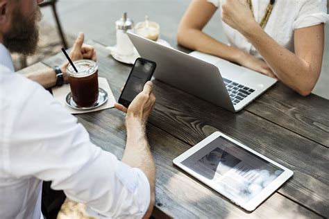 person sitting  front table white ipad silver macbook