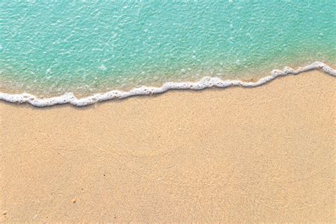 Soft waves with foam of blue ocean on the sandy beach 2196914 Stock