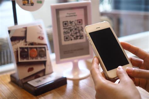 Hand using the phone to scan the QR code to receive discounts on