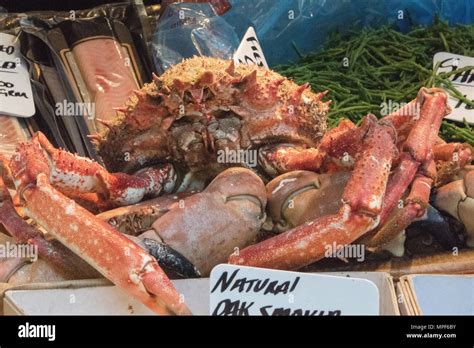 a large red coloured spider crab on sale on a fishmongers stall at