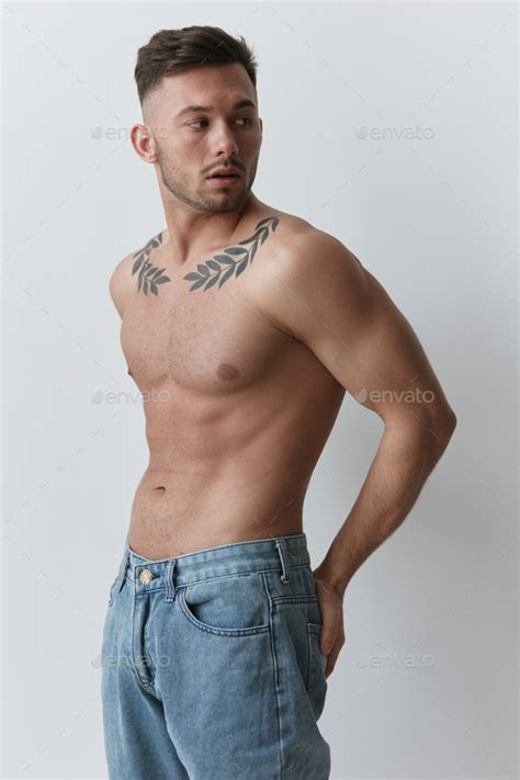 Sporty Sexy Muscular Handsome Naked Man holds hands on belt looks aside posing isolated on over