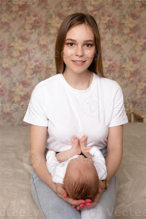 hermosa joven madre participación un bebé en su brazos mientras sentado