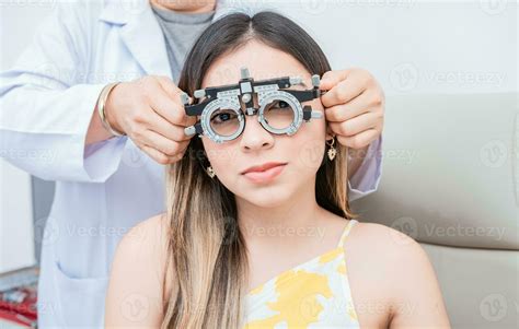 Hands of optometrist examining patient with optometrist trial frame