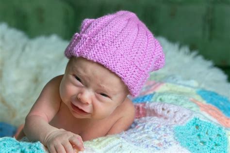 Premium Photo | Newborn baby with funny face little baby in pink cap is ...