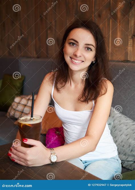 Beautiful Cute Brunette Girl Sitting in the Cozy Cafe Near the Window