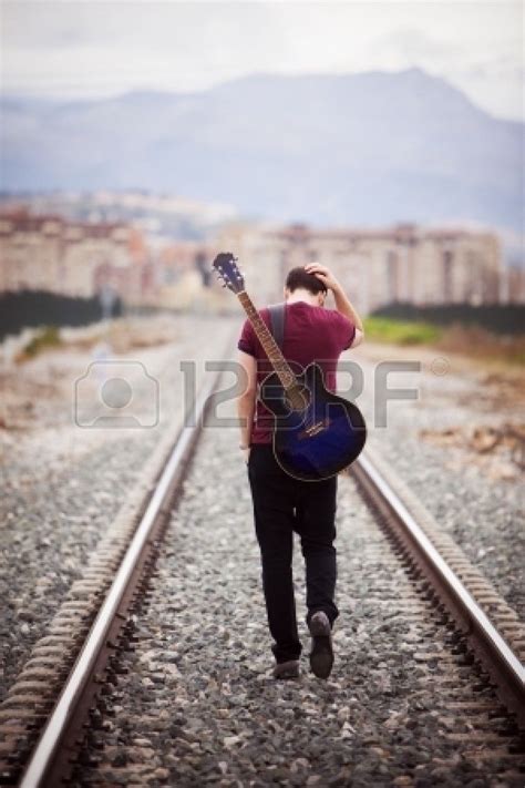 Young male musician walking with his acustic guitar. | Guitar senior ...