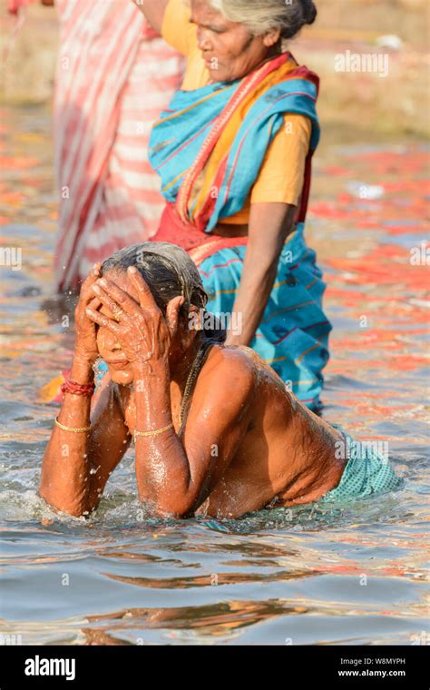 Indian Hindu women wearing saris perform early morning bathing rituals ...