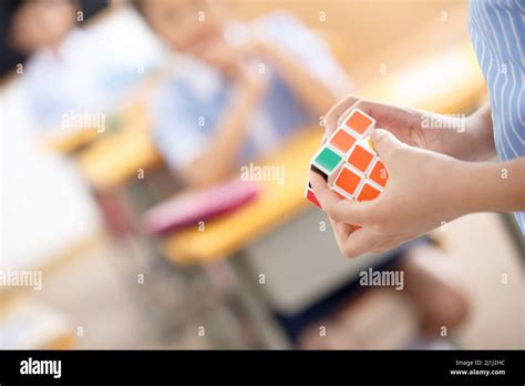 Elementary school students to play rubik's cube Stock Photo - Alamy