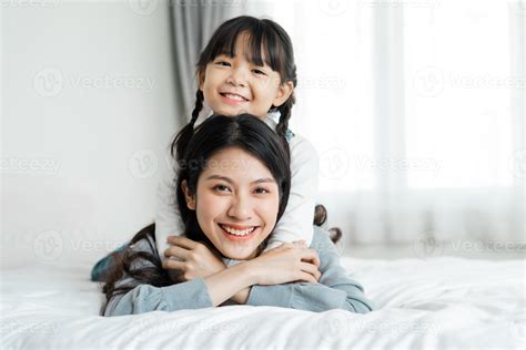 Asian mother and daughter image in bed 5732071 Stock Photo at Vecteezy