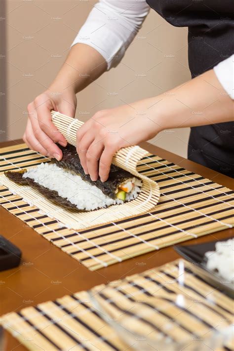 Woman chef rolling up japanese sushi containing sushi, roll, and ...