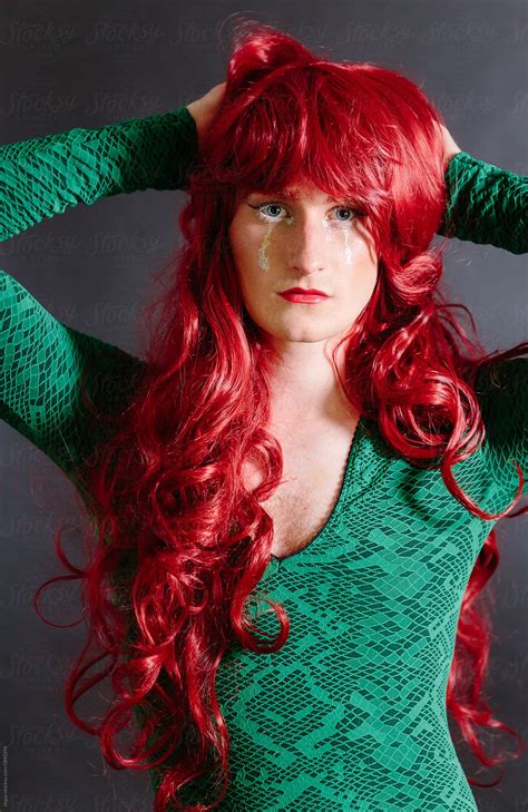 "Non Binary Guy In Drag Wearing Green Dress And Red Wig" by Stocksy