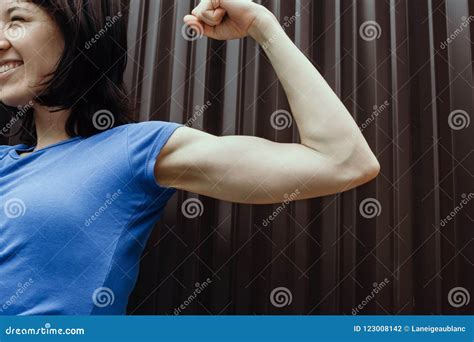 smiling woman flexing  biceps outdoors stock photo image  focus
