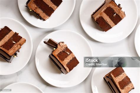 potongan kue cokelat hitam berlapis  atas piring putih foto stok