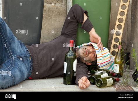 drunk man lying near trashcan in city street Stock Photo - Alamy