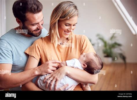 loving parents holding newborn baby  home  loft apartment stock