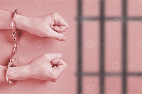 Hands in handcuffs, behind bars 11307808 Stock Photo at Vecteezy