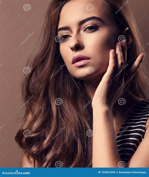 Beautiful Woman with Nude Natural Makeup and Long Brown Curly Ha Stock