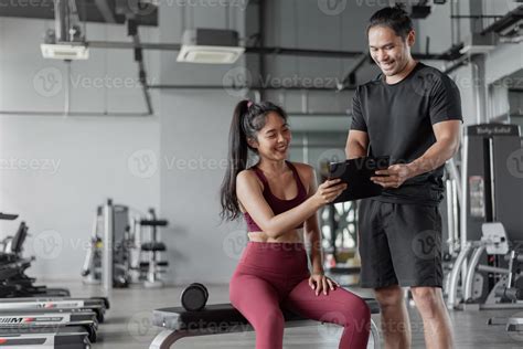 Asian woman exercise with personal trainer in gym. Personal trainer