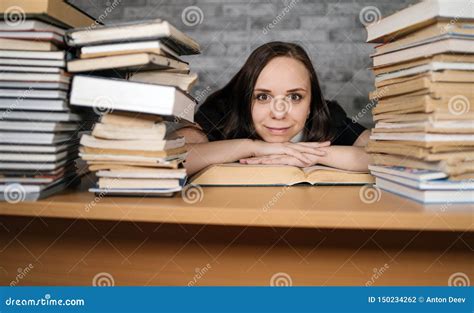 Beautiful Woman Student Studying with a Lot of Paper Books on the Table ... 