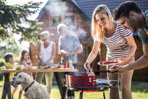 happy extended family preparing barbecue   backyard stock photo