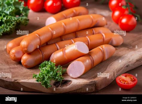 grilled frankfurter sausages styled  wooden board  tomotoes